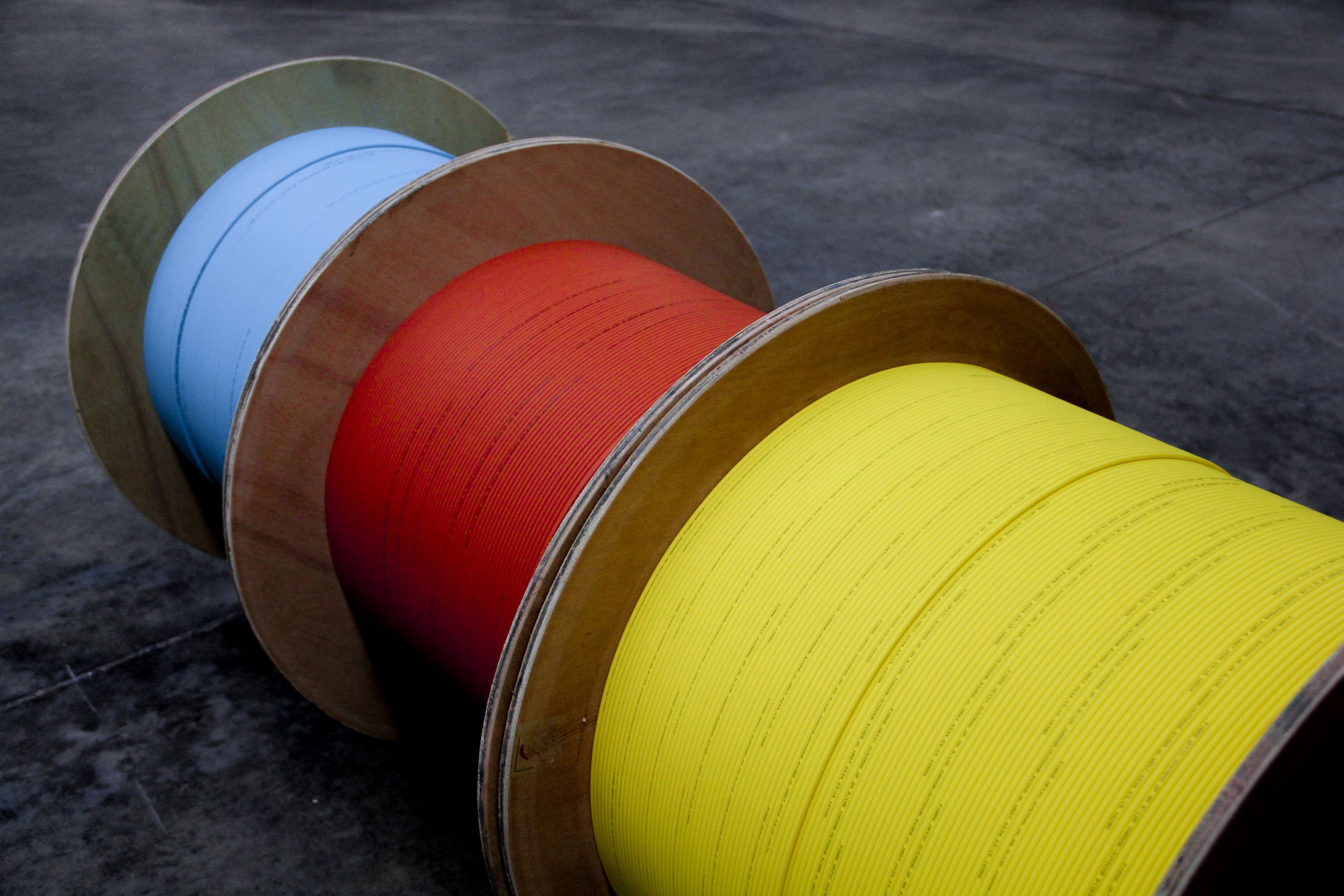 Three cable drums in yellow, red and blue