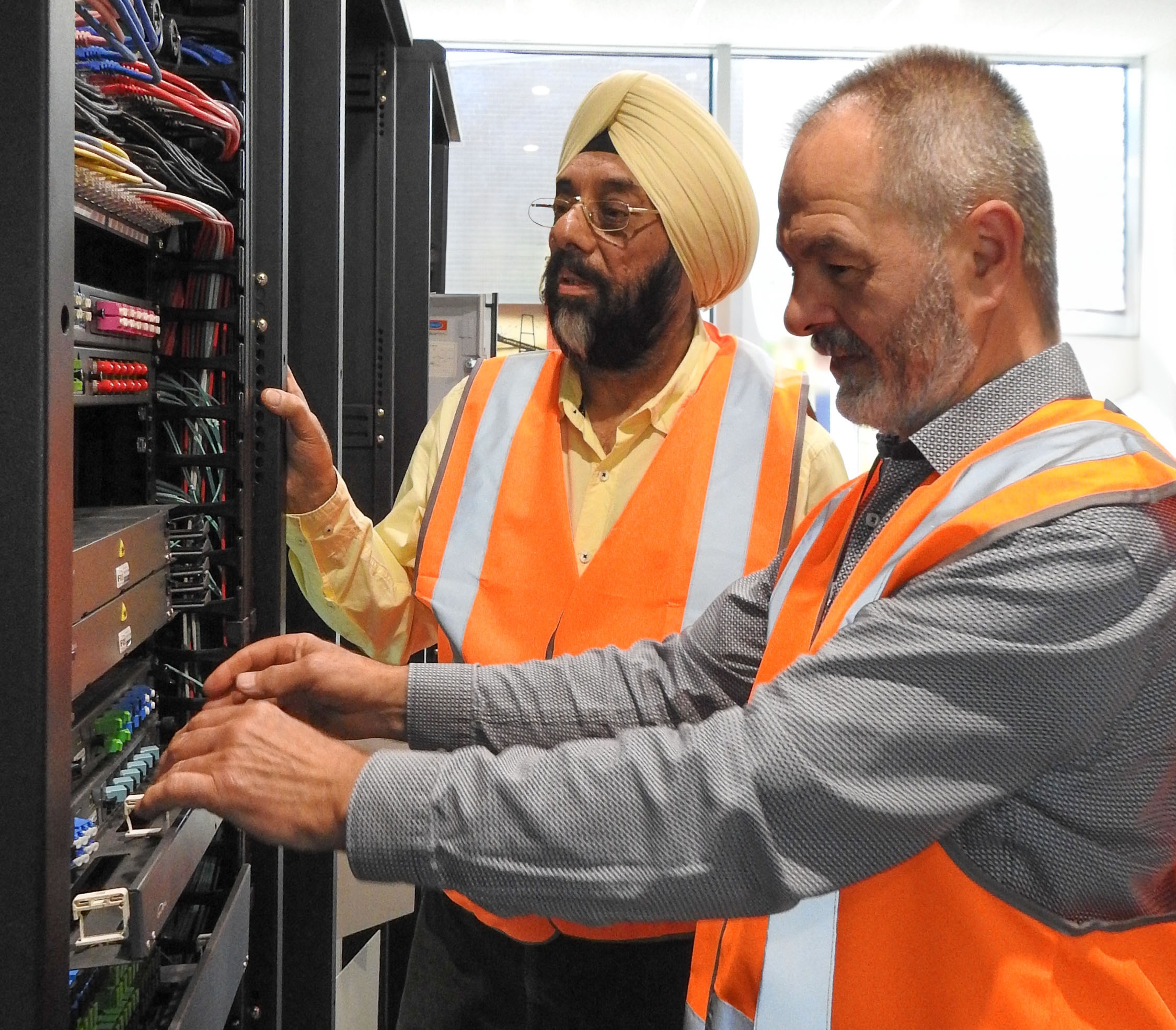 Two colleagues inspecting settings of equipment